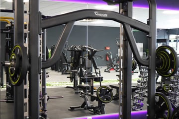 Moderne Kraftstation mit Langhantel und Gewichten im EASYFITNESS-Studio