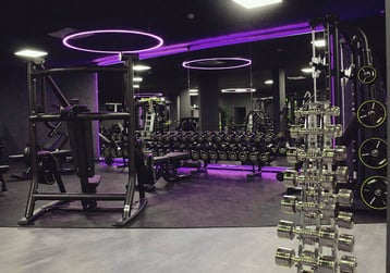 Freihantelbereich im EASYFITNESS Maisach mit Hantelbänken, Gewichten und violetter Beleuchtung
