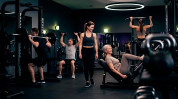Belebter Trainingsbereich im EASYFITNESS Lifestyle & Sport Studio mit Trainierenden an verschiedenen Kraftgeräten
