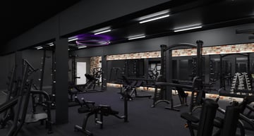 Dunkel gestalteter Krafttrainingsbereich mit modernen Fitnessgeräten und violetter Beleuchtung